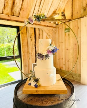 Wedding cake: A white cake with purple flowers on top