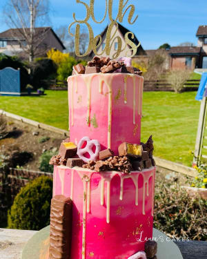 Celebration cake: A pink cake with gold and pink icing on top