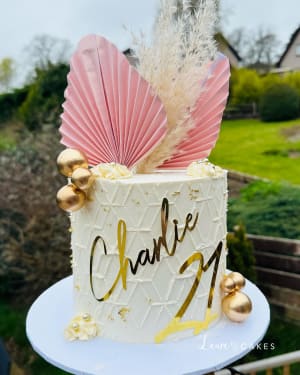 Celebration cake: A pink and gold feather on top