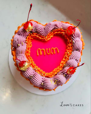 Celebration cake: A heart shaped cake with the word m on it