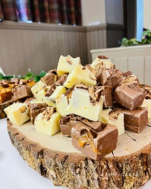 Wedding cake: A white plate topped with a piece of chocolate and chopped up