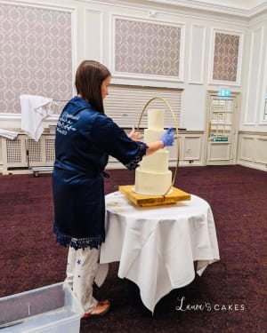 Wedding cake: A woman is putting a cake on a table