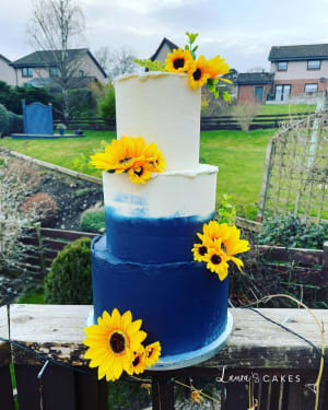 Celebration cake: A blue and white cake with sunflowers on top