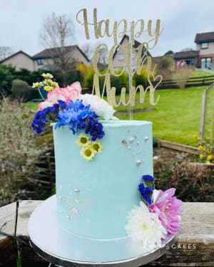 Celebration cake: A blue cake with gold glitter and flowers