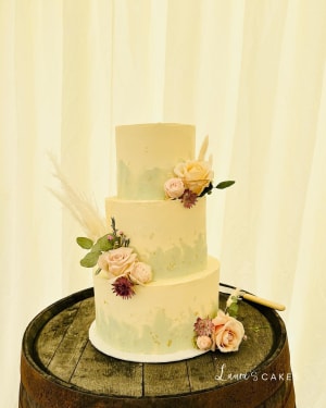 Wedding cake: A three tiered cake with flowers and feathers