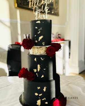 Wedding cake: A black and gold wedding cake with red roses