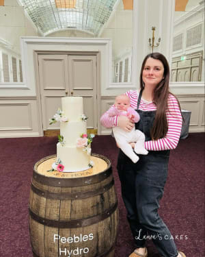 Wedding cake: A woman holding a baby next to a barrel