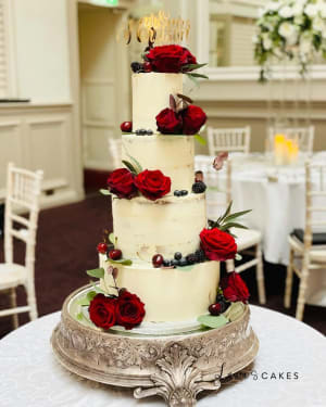 Wedding cake: A three tiered cake with red roses and berries