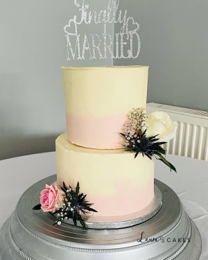 Wedding cake: A white and pink om cake topper