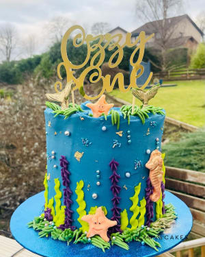 Celebration cake: A blue cake with gold letters and sea creatures