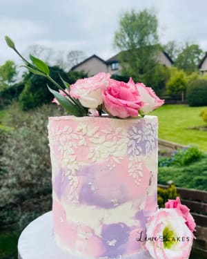 Celebration cake: A pink and white cake with flowers on top