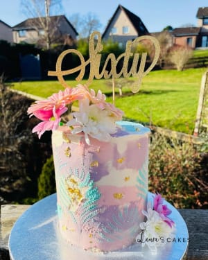 Celebration cake: A pink and gold cake with flowers on top