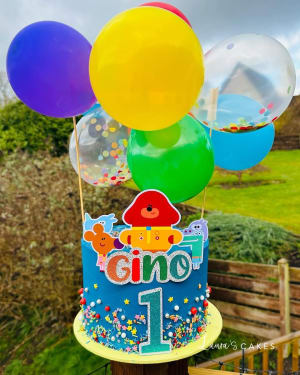 Celebration cake: A birthday cake with balloons and a number one