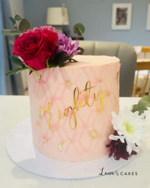 Celebration cake: A pink cake with gold foil and flowers