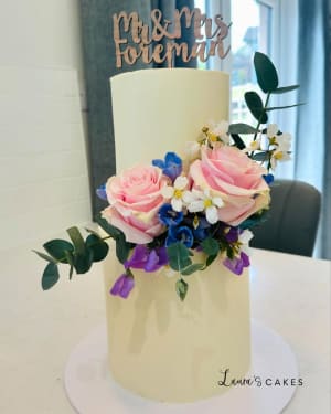Wedding cake: A white cake with pink and blue flowers on top