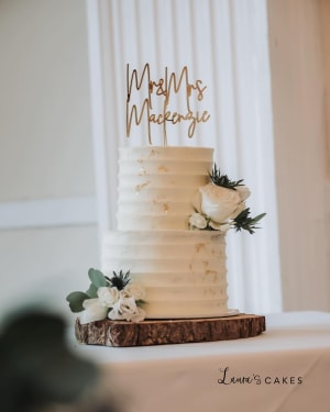 Wedding cake: A white wedding cake with gold lettering and flowers