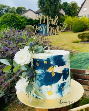 Wedding cake: A blue and gold cake with white flowers
