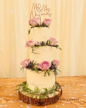 Wedding cake: A three tiered cake with pink flowers and greene