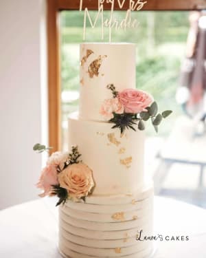 Wedding cake: A white wedding cake with gold and blush flowers