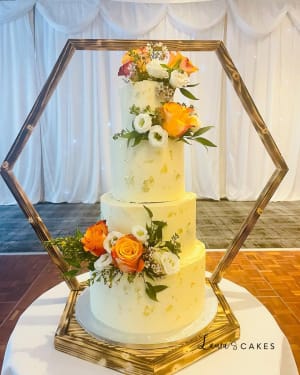 Wedding cake: A white wedding cake with orange and yellow flowers