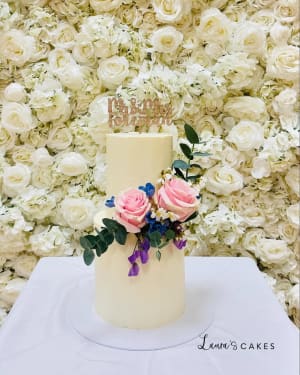 Wedding cake: A white cake with pink and blue flowers on top