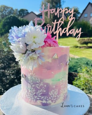 Celebration cake: A pink and purple cake with flowers on top