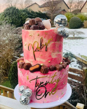 Celebration cake: A pink cake with gold and chocolate decorations
