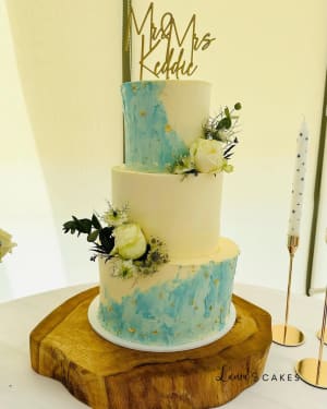 Wedding cake: A three tiered cake with blue and white flowers