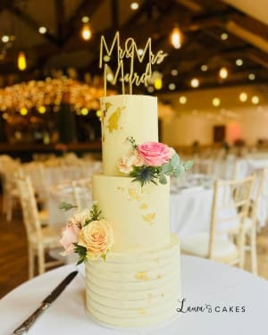 Wedding cake: Flowers and a gold topper