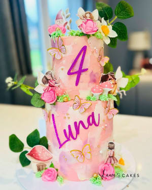 Celebration cake: A pink cake with flowers and butterflies on top