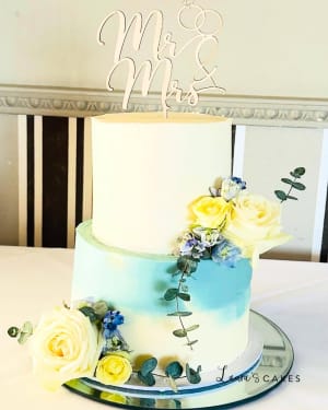 Wedding cake: A white cake with blue and yellow flowers on top