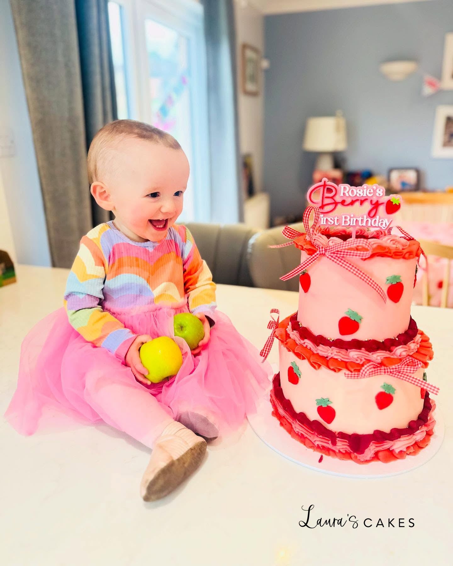 Celebration cake: A baby girl sitting next to a cake
