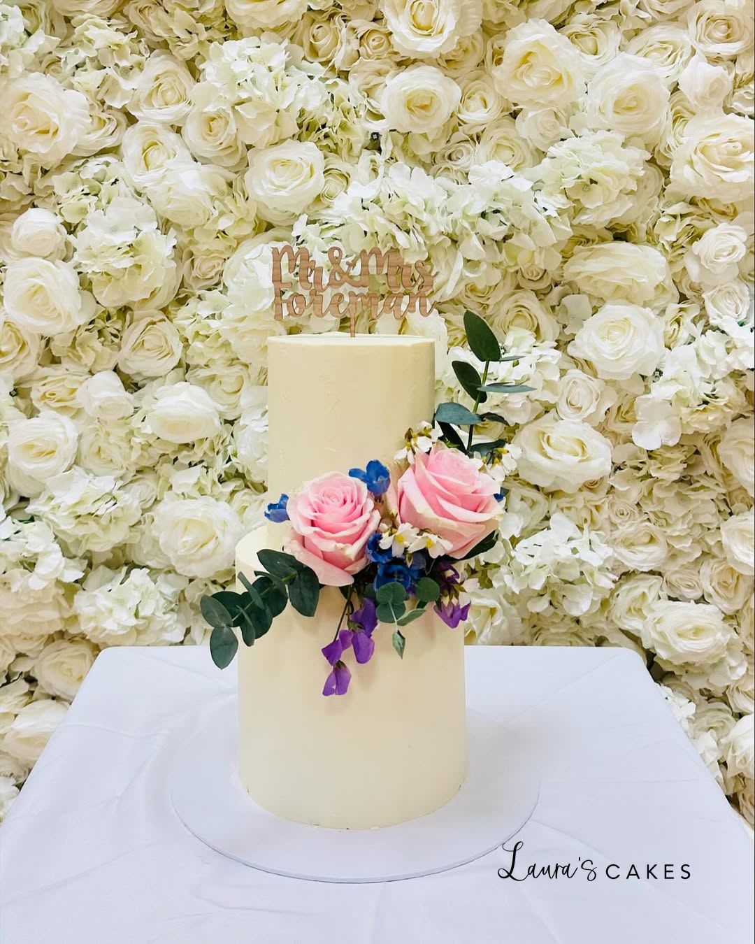 Wedding cake: A white cake with pink and blue flowers on top