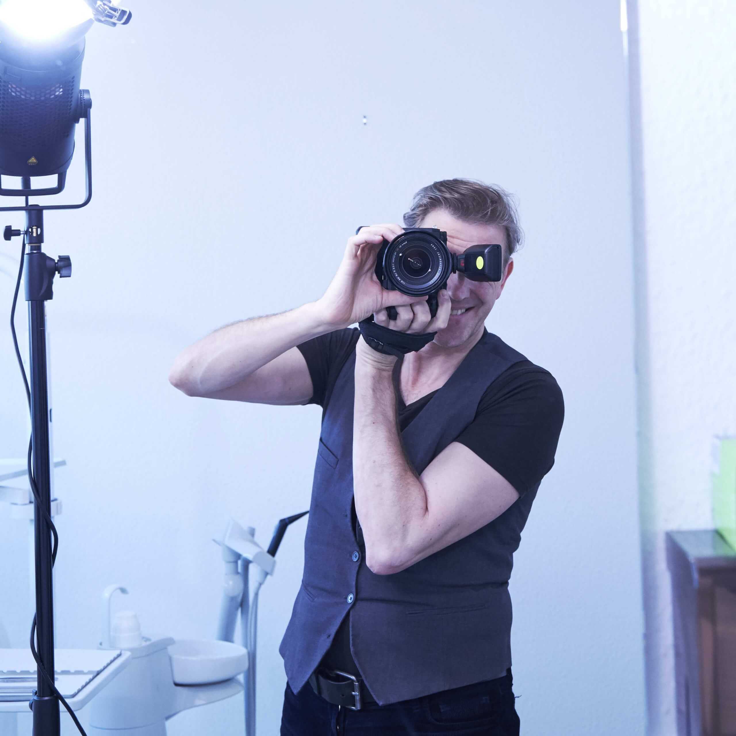 Rasmus Schübel Fotograf Münster professionelles Business Portrait Video Website Branding Experte sitzend Kamera