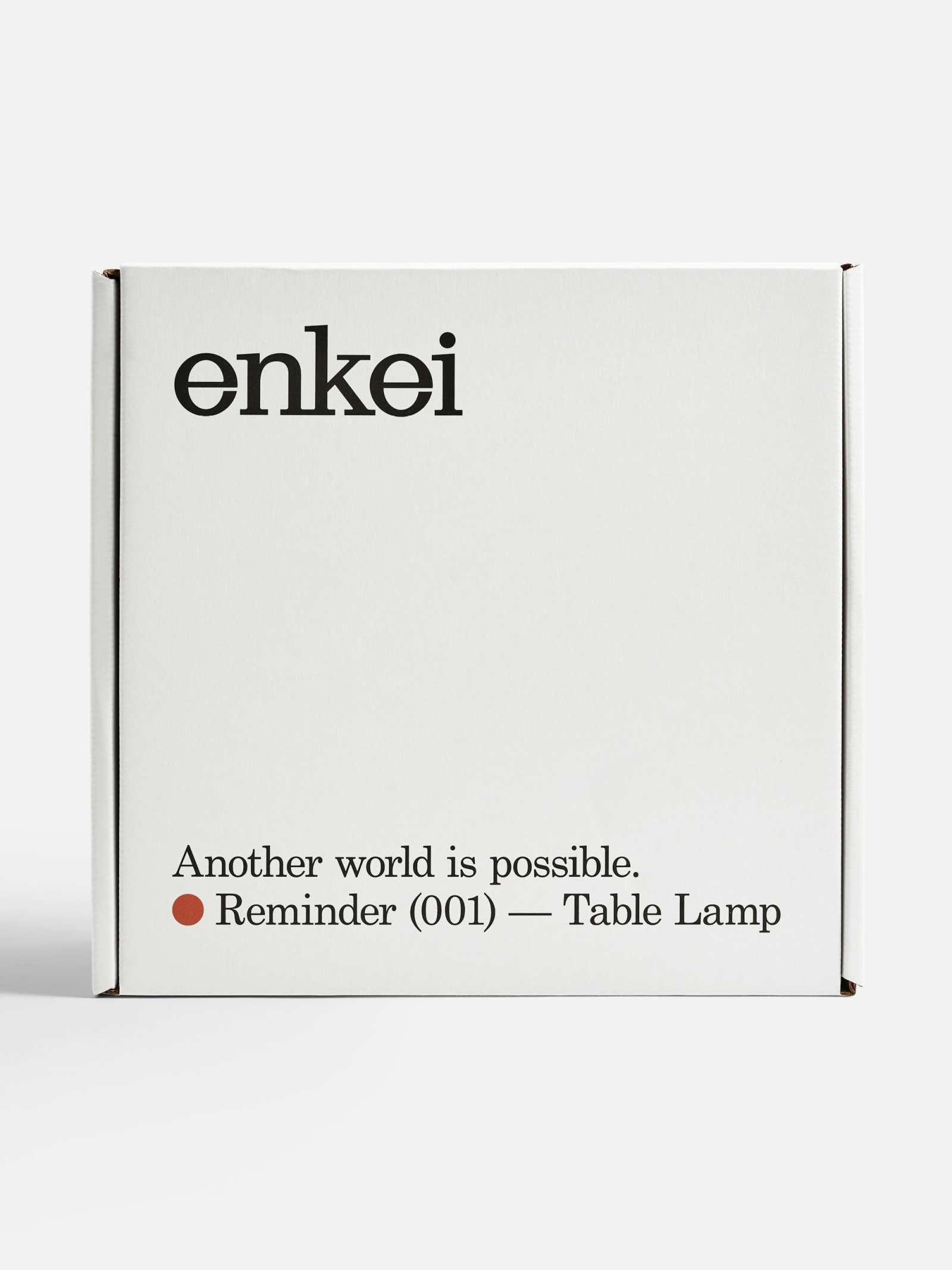 Enkei Reminder (001) Table Lamp white corrugated cardboard shipping box front face with wordmark and product name on grey background