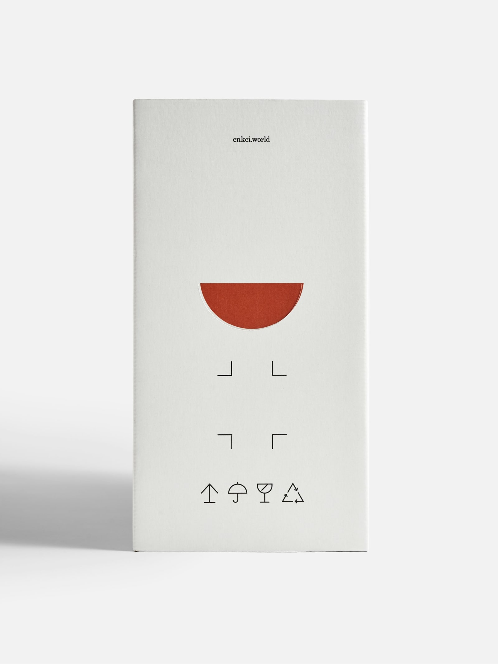 Enkei Reminder (001) Table Lamp box side panel showing terracotta semicircle lamp silhouette, corner marks, and handling icons on white background