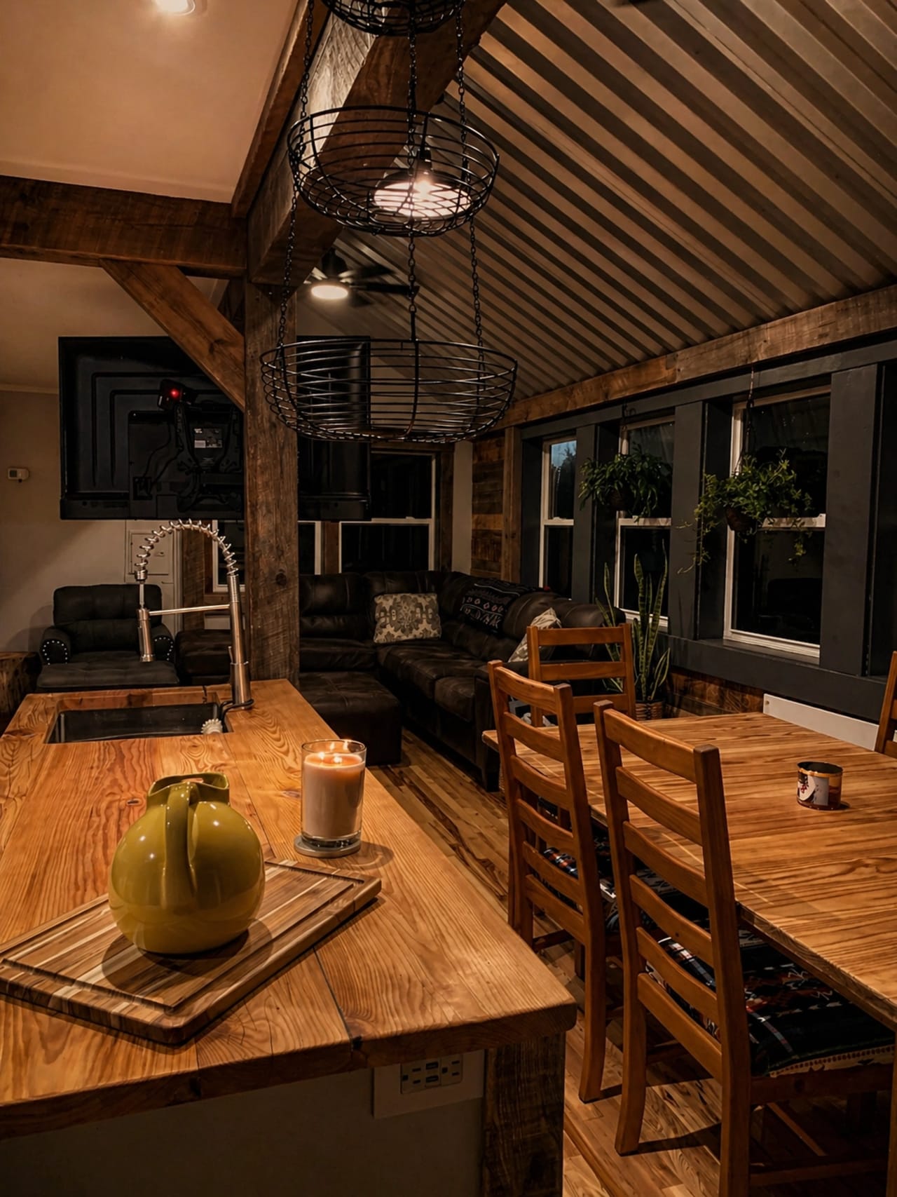 Adirondack camp interior with wood countertops, corrugated metal ceiling, rough-sawn beams, and warm cabin lighting