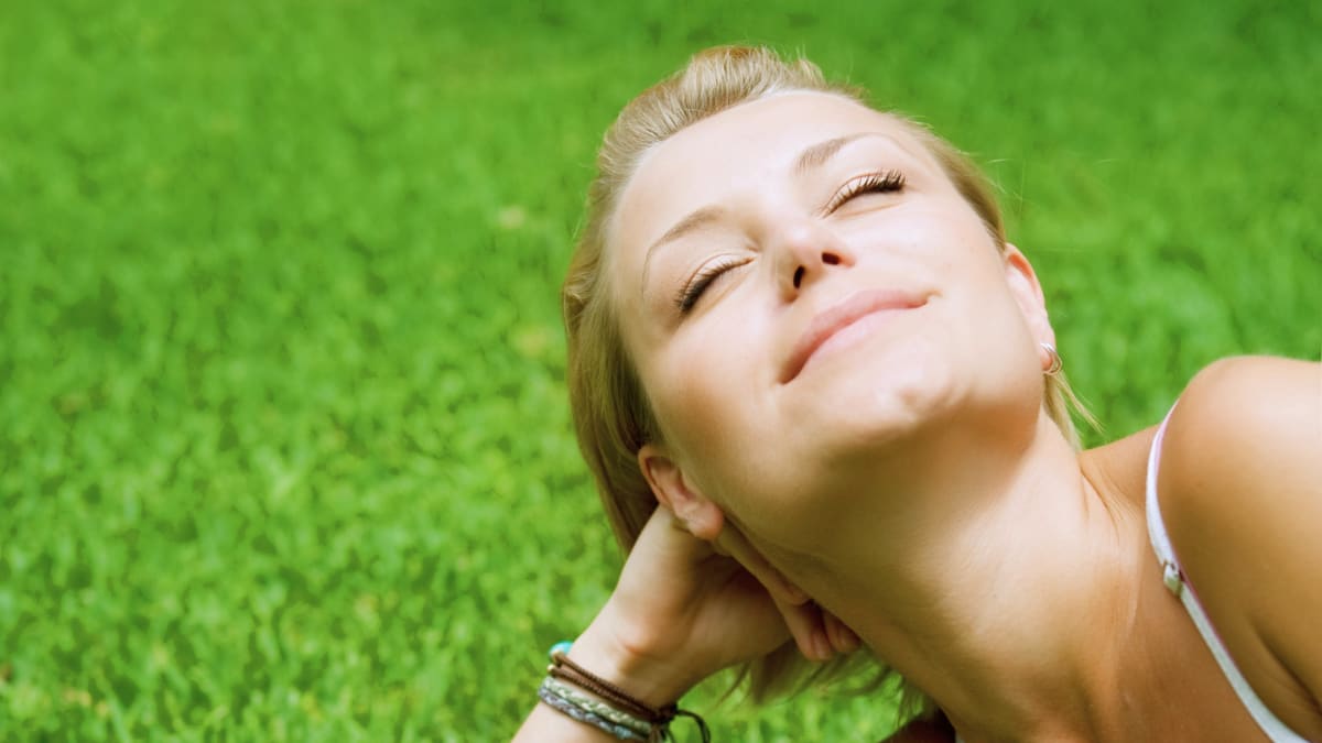 Femme qui sent une bonne odeur sur l'herbe