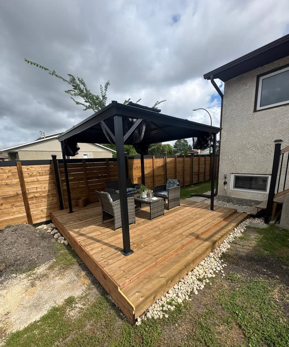 Ground-level wood deck with gazebo and privacy fence