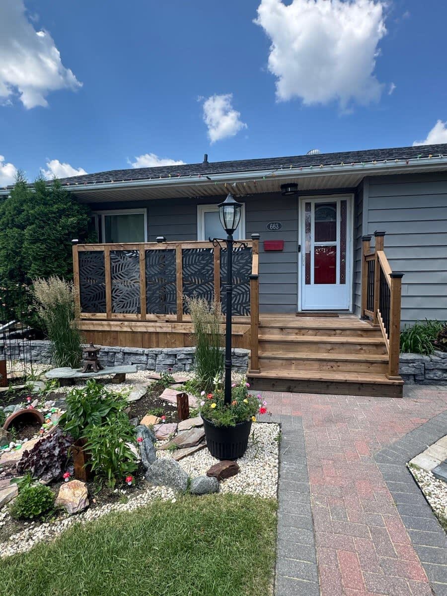 Front porch with wood railing and decorative metal privacy screens