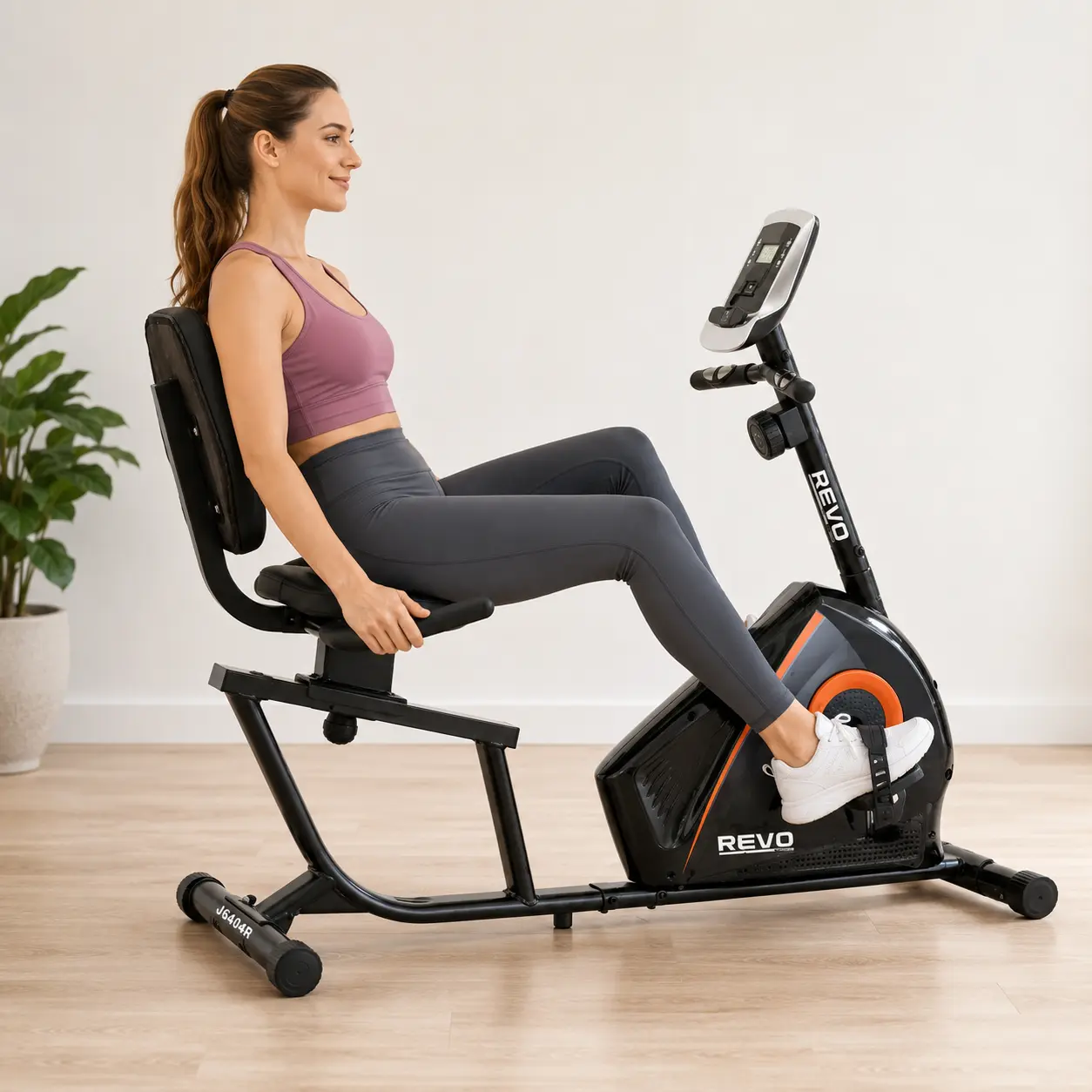 Woman exercising at home on the Revo JS-604R magnetic recumbent bike in a seated, back-supported position