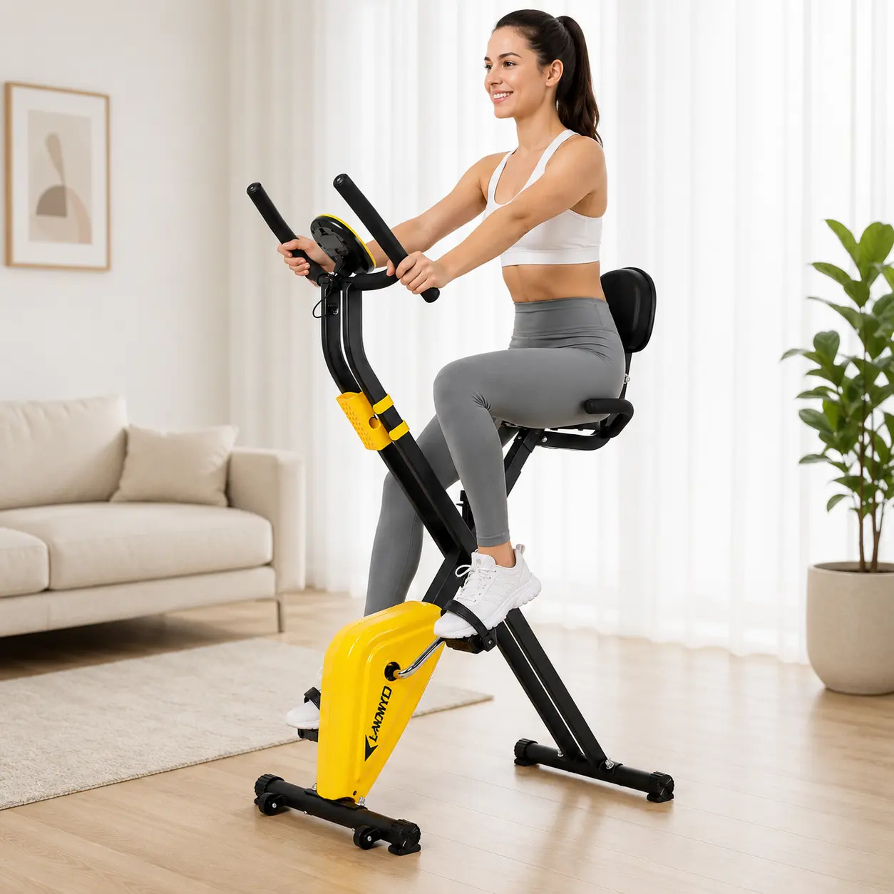 Smiling woman training on the yellow and black foldable X Fit exercise bike at home