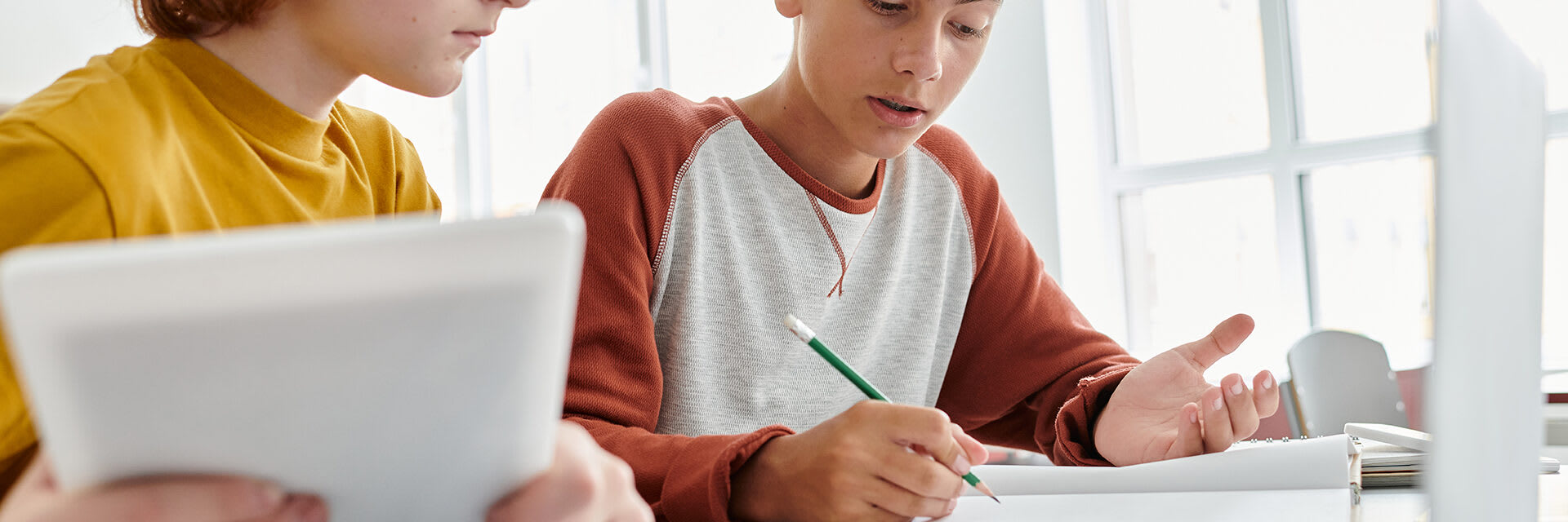 Two teenagers are working on school assignments.