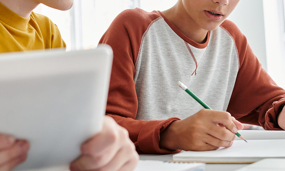 Two teenagers are working on school assignments.