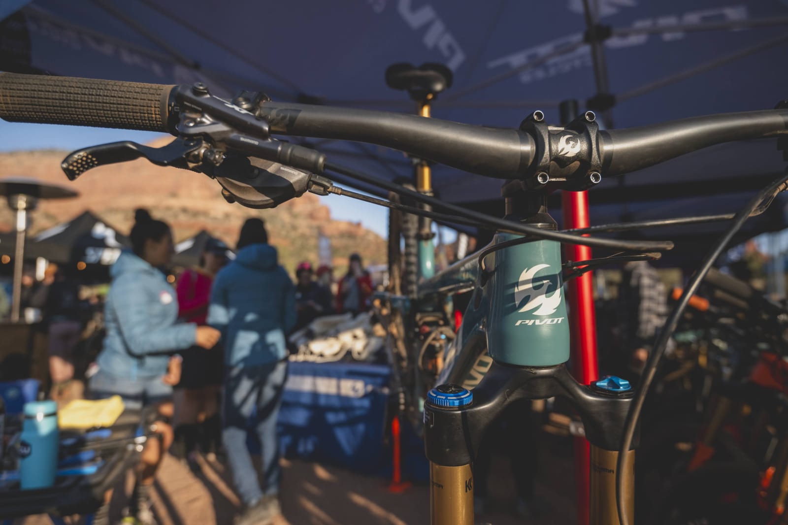 trail 429 pivot bike in a bike stand. head tube facing front with people mingling in background