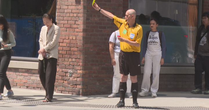 Performance artists use soccer referee personas to promote pedestrian safety at a busy Toronto intersection