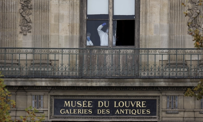 Các thành viên của đội pháp y kiểm tra một cửa sổ tại bảo tàng Louvre sau vụ cướp hôm 19/10. Ảnh:Reuters