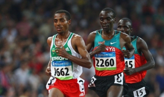 Bekele (bib 2662) chạy trước Kipchoge (2260) trên đường chạy 5.000m nam Olympic 2008. Ảnh: Runners World