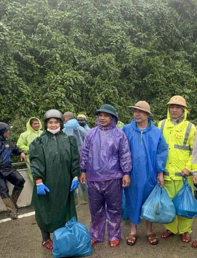Ông Tám (thứ 2 từ phải sang) cùng các thành viên gia đình và lực lượng chức năng mang cơm tới cho người mắc kẹt trên đèo Lò Xo, chiều 27/10. Ảnh: Nguyễn Thanh Hải