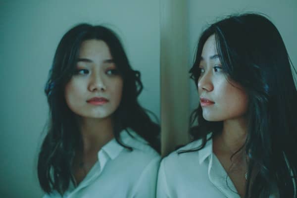 A woman looking at her reflection in a mirror.